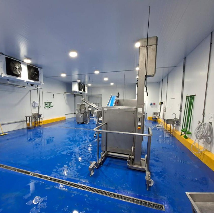 Sala de proceso con piso epóxico azul y paneles frigoríficos